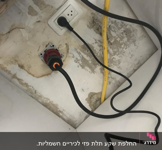 שקע חשמל עם כבלים מחוברים לקיר מתקלף